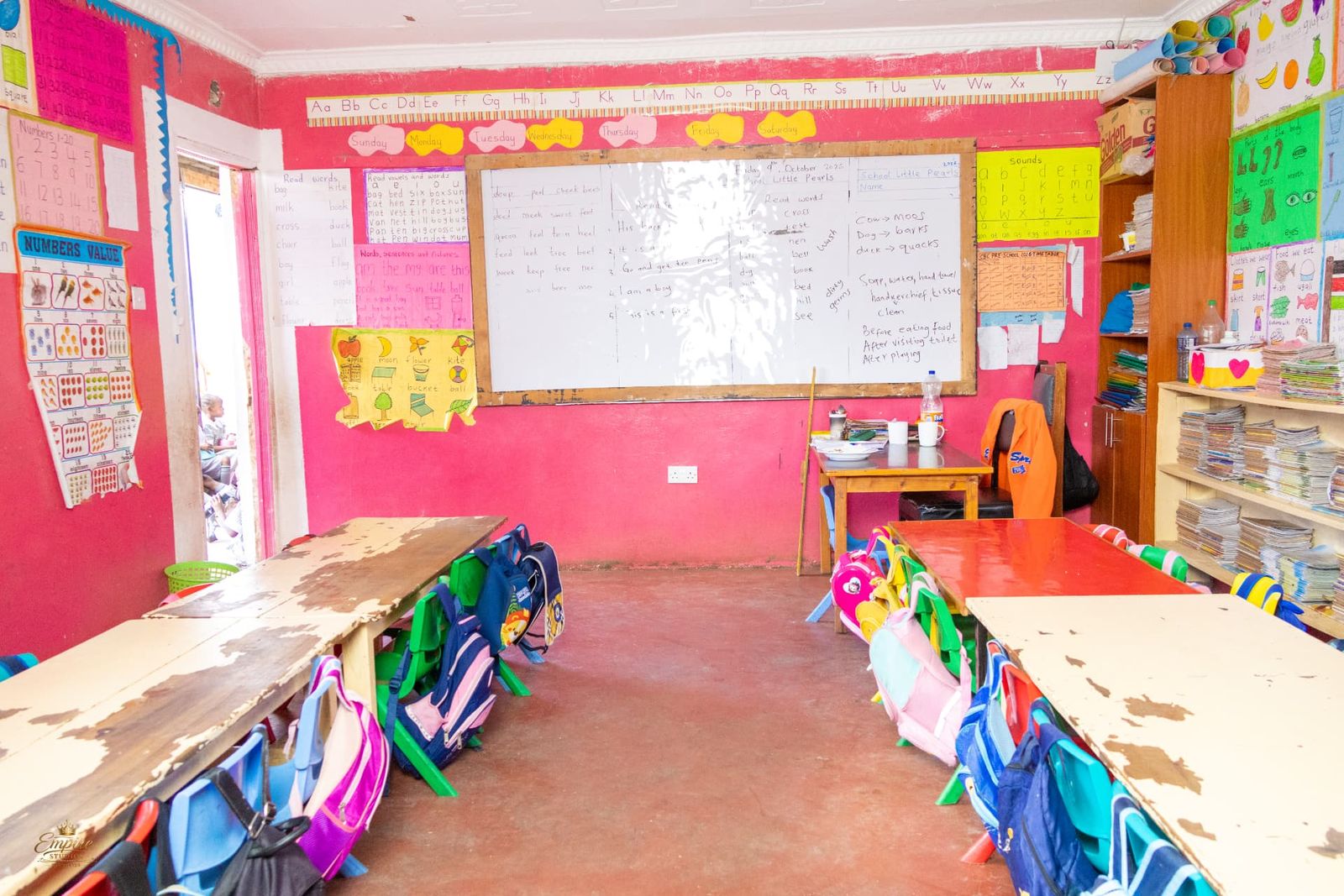 A colourful pre-school classroom with phonics charts, reading words and a hand-washing lesson