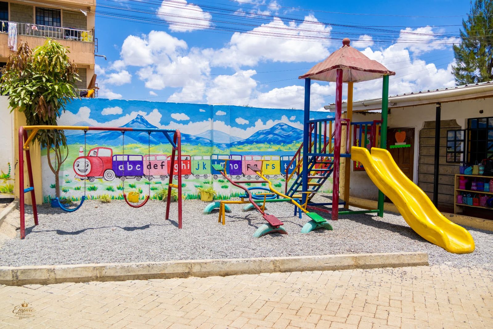 The Little Pearls playground with swings, see-saws, a slide and an alphabet train mural